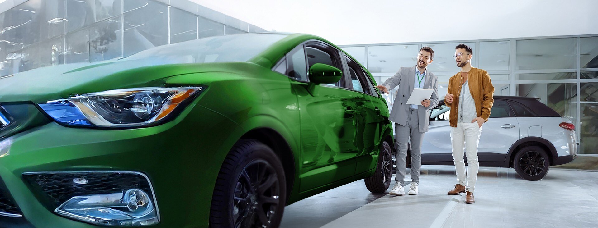 Mężczyzna ogląda w salonie samochodowym nowe, zielone auto