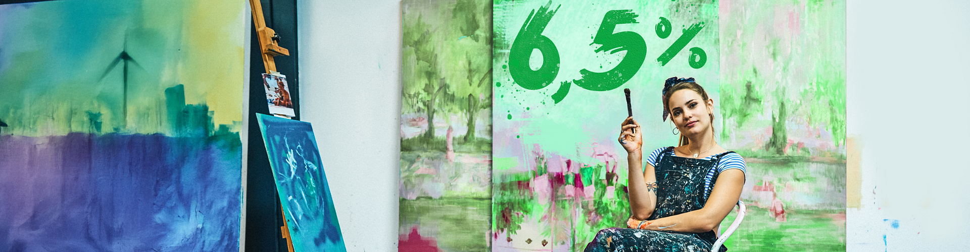 Malarka siedzi przed obrazem, na którym znajduje się napis "6,5%"