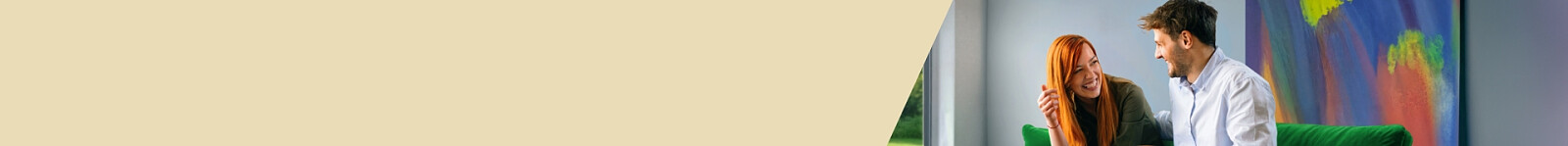 Kobieta i mężczyzna rozmawiają rozbawieni siedząc w nowoczesnym salonie