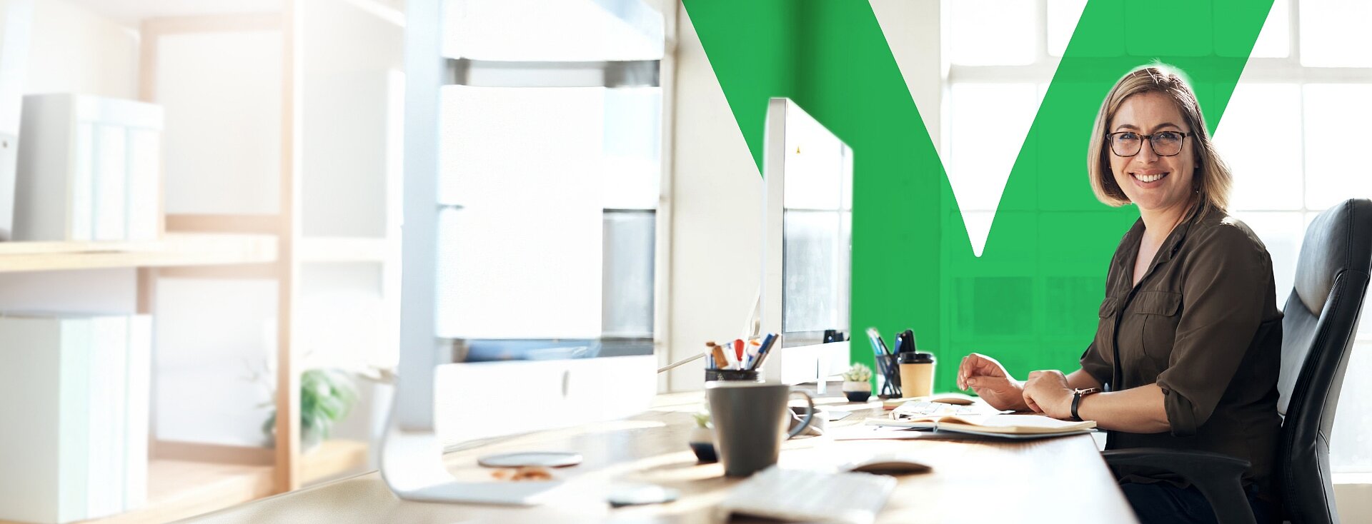 Uśmiechnięta księgowa siedzi w swoim biurze współpracując z VeloBank