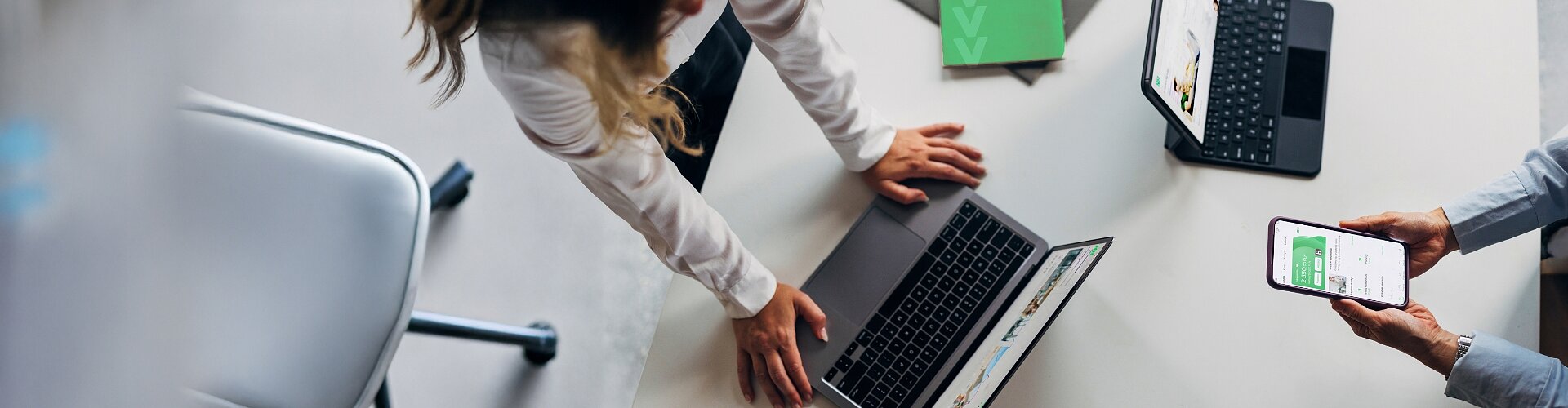 Kobieta i mężczyzna korzystają z laptopa, tableta i smartfona nawiązując do dostępności kanałów kontaktu.