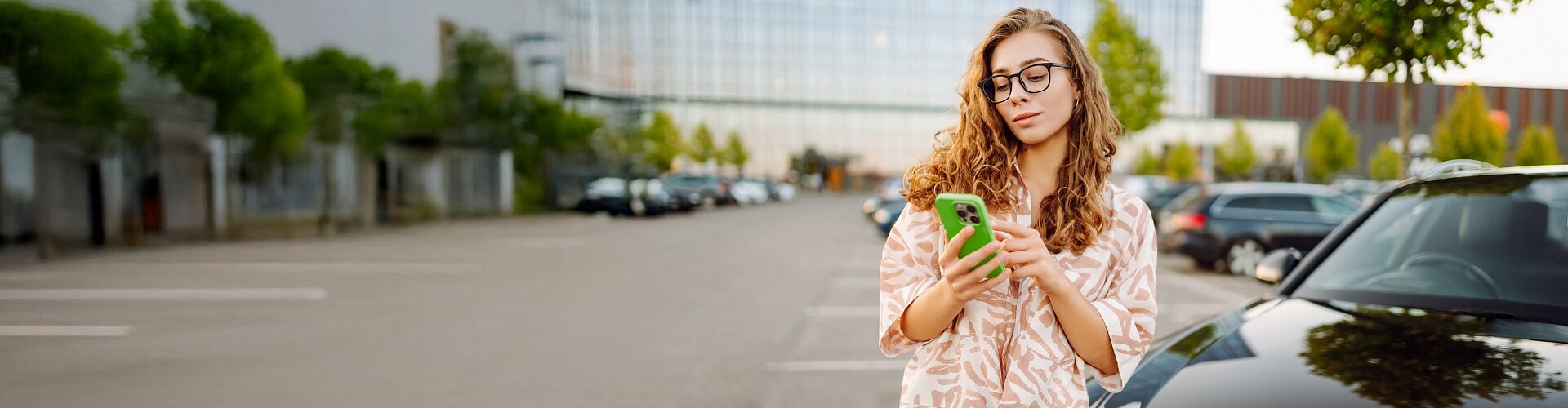 Pani płaci za postój samochodu korzystając z aplikacji mobilnej.