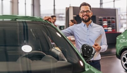 Zadowolony mężczyzna odbiera swój nowy samochód pozyskany dzięki ofercie VeloLeasing dla Firm