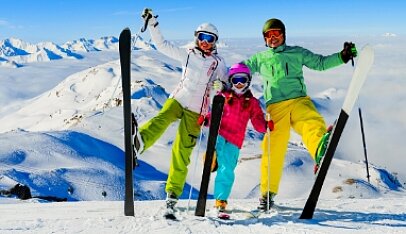 Szczęśliwa rodzina w kombinezonach narciarskich pozuje podczas wycieczki w góry