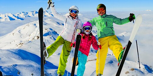 Szczęśliwa rodzina w kombinezonach narciarskich pozuje podczas wycieczki w góry