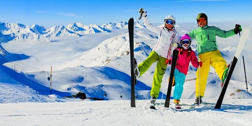 Szczęśliwa rodzina w kombinezonach narciarskich pozuje podczas wycieczki w góry