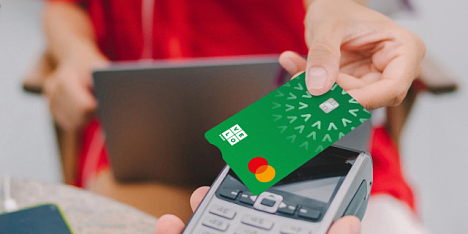 Karta płatnicza VeloBank przyłożona do terminalu płatniczego.