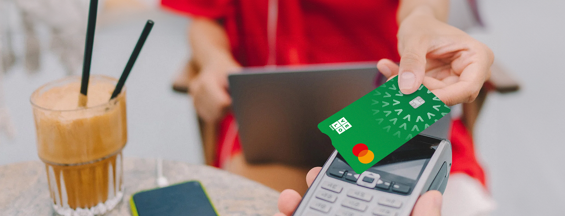 Karta płatnicza VeloBank przyłożona do terminalu płatniczego.