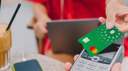 Karta płatnicza VeloBank przyłożona do terminalu płatniczego.