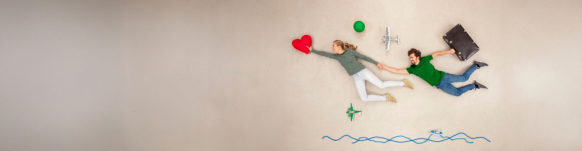 Młoda para unosząc się leci w kierunku czerwonego serca