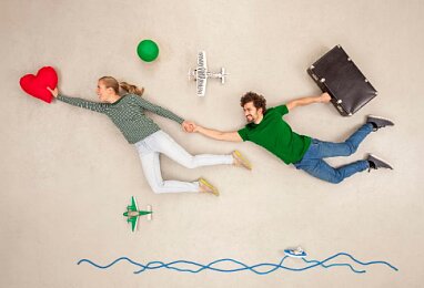 Młoda para unosząc się leci w kierunku czerwonego serca