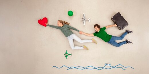 Młoda para unosząc się leci w kierunku czerwonego serca