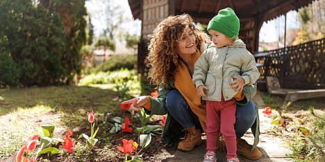 Mama z dzieckiem w wiosennej scenerii.