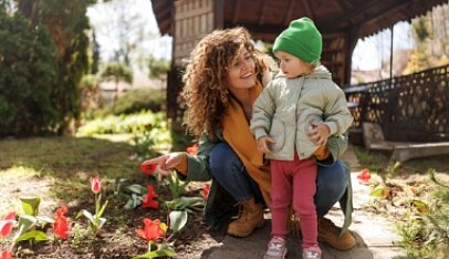 Mama z dzieckiem w wiosennej scenerii.