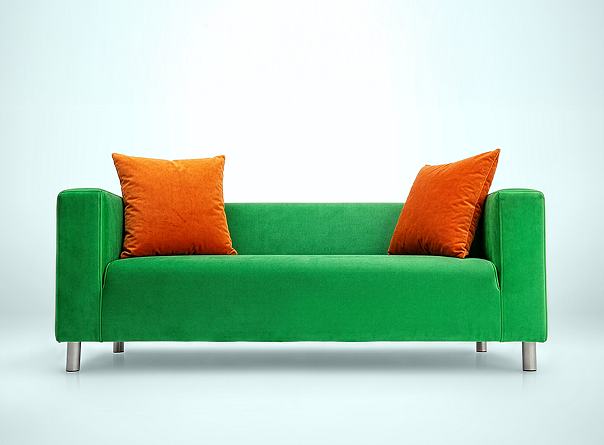 Zielona sofa z pomarańczowymi poduszkami symbolizująca wygodę w ofercie ubezpieczeniowej VeloBank