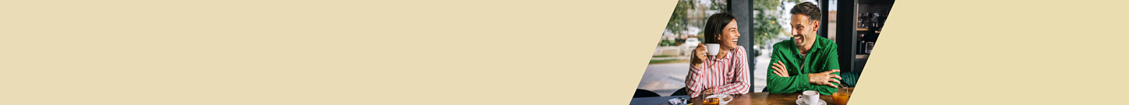 Roześmiana para rozmawia w kawiarni po skorzystaniu z Promocji VeloPolecenie